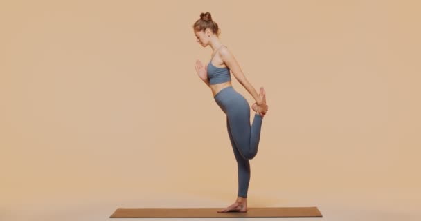 Atlética mujer caucásica practica yoga pose para estirar el músculo, calentar. Hembra sana haciendo ejercicio de pilates — Vídeos de Stock