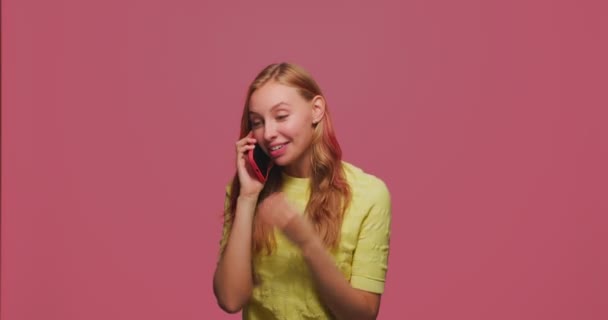 Chica joven positiva mantener la llamada por teléfono, hablar, mantener una conversación amistosa, sonreír, contar buenas noticias animado — Vídeos de Stock