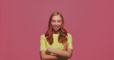Gülümseyen mutlu genç kız flört ediyor, göz kırpıyor, iyimserlikle kameraya bakıyor, kendine güveniyor, büyülüyor.
