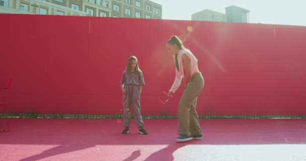 Advertentievideo van de dansschool. gemengde race vrouwelijke danser coach onderwijs tiener meisje dansen buiten in zonlicht. — Stockvideo