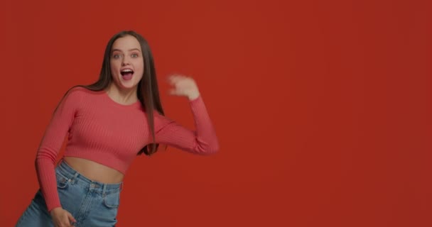Ευτυχισμένο κορίτσι να κουνάει το χέρι, καλωσόρισες, χαιρετάς, δείχνεις εκτός πλάνου. Διαφημιστικό βίντεο για διαφήμιση σε ηλεκτρονικό κατάστημα — Αρχείο Βίντεο
