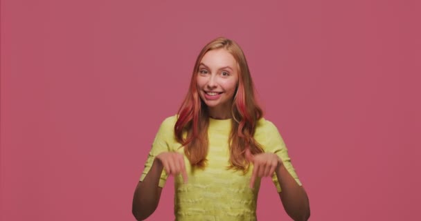 Leende ung flicka pekar nedåt, rekommendera länk nedan, visar plats för reklam, PR-information — Stockvideo