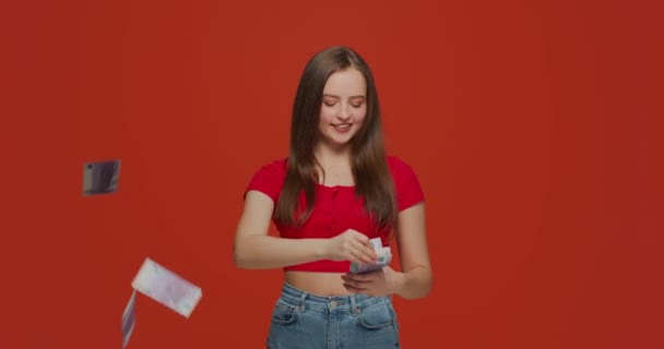 Joyful rich generous young girl scattering money, throwing around cash, wasting euro carelessly, enjoying wealth — Stock Video