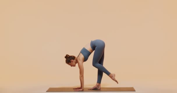 Yoga pilates träning för kvinnans välbefinnande och flexibilitet. Flexibel passform ung flicka träning sträcker sig i studio — Stockvideo