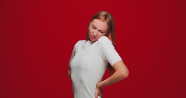 Mal au dos. Jeune fille malade souffrent mal au bas du dos, maladie rénale, syndrome pms ou cycle sur fond rouge studio — Video