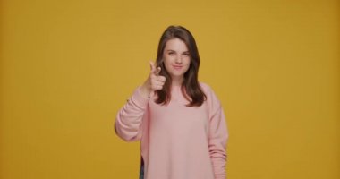 Hey sen, seçim jesti. Kamerayı parmaklarıyla işaret eden güzel beyaz kız sarı arka planda adayı seçiyor.
