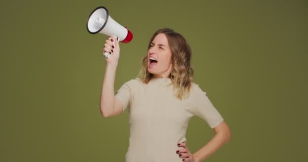 Chica gritar en altavoz. Mujer joven y confiada eco-activista gritando en megáfono sobre fondo verde natural — Vídeos de Stock