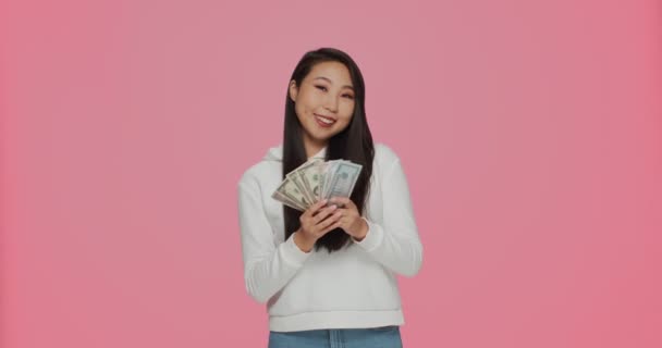 Felice giovane ragazza asiatica ricca gettando soldi in giro, spargimento di denaro contante dollaro. Fortuna, jackpot, concetto di vincita della lotteria — Video Stock