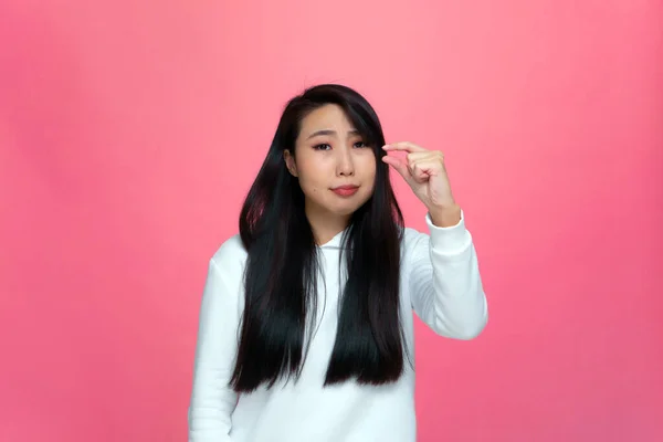 Upset young asian girl showing small size gesture with fingers, ask little bit more discount or salary increase — Stock Photo, Image