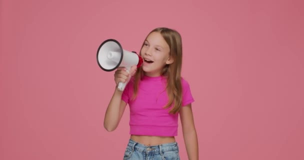 Küçük kız çığlık atıyor, megafonla konuşuyor, pembe arka planda satış duyurusu yapıyor. Çocuklar çevrimiçi mağaza reklamları — Stok video