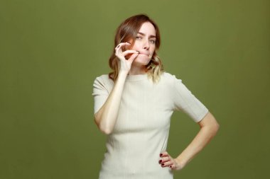 Ciddi güvenilir bir genç kız sessiz olacağına ve sır tutacağına söz veriyor. Yeşil stüdyo geçmişinde sessizlik jesti yapıyor.