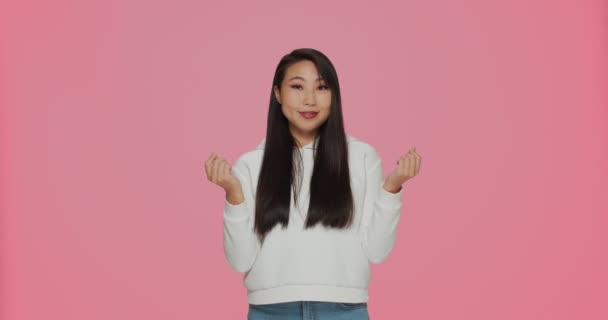 Ge mig kontanter. Ganska asiatisk flicka gör pengar gest, ber om betalning, underhåll, donation på rosa studio bakgrund — Stockvideo