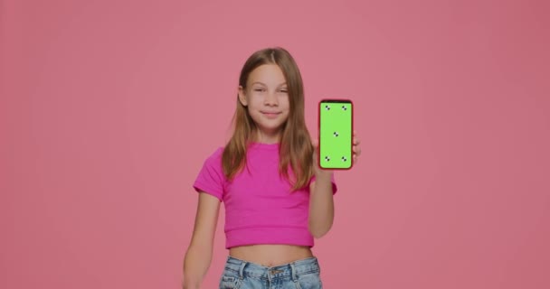 Bambina carina che punta il dito sullo schermo verde del modello di telefono in mano. Moderna pubblicità dispositivo di fascia alta — Video Stock