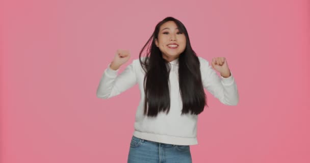 Overjoyed excited young asian girl make yes winner gesture, dancing, gesturing feel happy euphoric triumph win — Stock Video