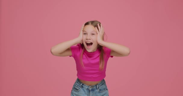 Sorprendido niño niña gritando wow, sí en triunfo, sorprendido sorprendido por inesperada victoria en el fondo del estudio rosa — Vídeo de stock