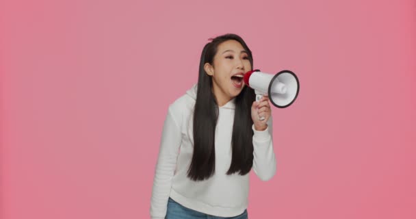 Güzel Asyalı genç kız megafonla bağırıyor, satış teklifini duyuruyor, indirim ilan ediyor. Çevrimiçi mağaza reklamları — Stok video