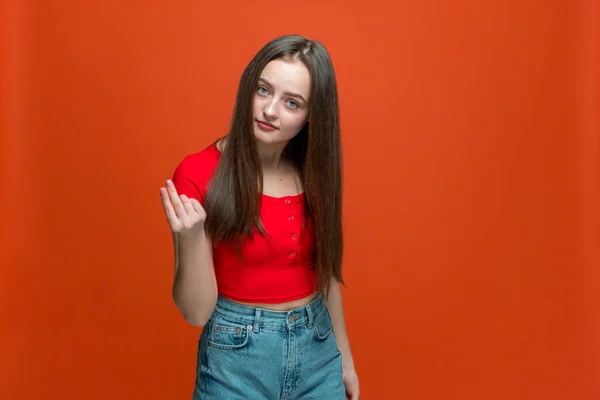 Gadis muda modern melakukan gerakan uang dengan tangan, meminta pembayaran gaji, sumbangan, utang pada latar belakang studio oranye — Stok Foto