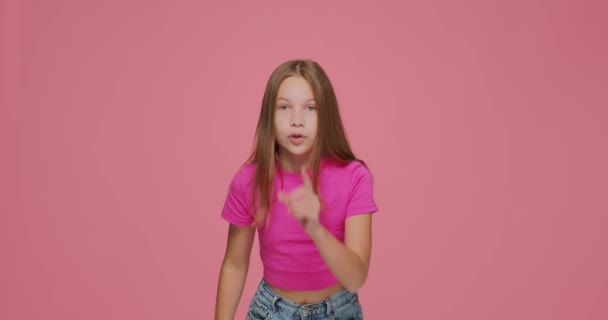 Shh silence gesture. Child girl hold finger on lips gesturing to be silent, to keep secret on pink background — Stock Video