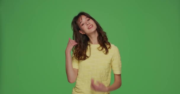 Pretty young girl show call me gesture, smiling, offer communication. Lets contact by phone. Chromakey green background — Stock Video