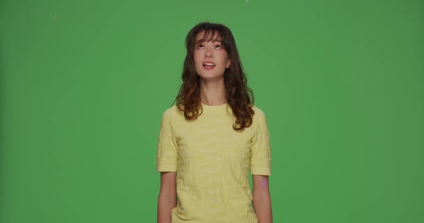 Glad ung flicka hoppar under konfetti glitter regn, fira semester, ha kul på kroma nyckel grön bakgrund — Stockvideo