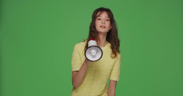 Σύγχρονη νεαρή κοπέλα φωνάζει σε μεγάφωνο σε chromakey πράσινο φόντο. Διαφήμιση με μεγάφωνο, προώθηση επιχειρήσεων — Αρχείο Βίντεο