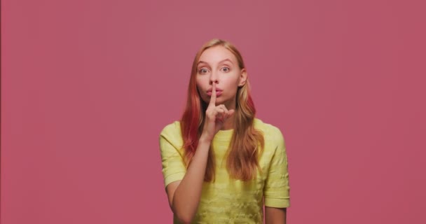 Жест молчания. Молодая девушка держит палец на губах, жестикулируя молчанием, чтобы хранить тайные сплетни, тишину. Концепция конфиденциальности — стоковое видео