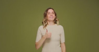 Gülümseyen genç bir kadın başparmak kaldırıyor, servis öneriyor, mutlu bir kız tavsiye veriyor, beğenisini sunuyor. İyi bir teklif.