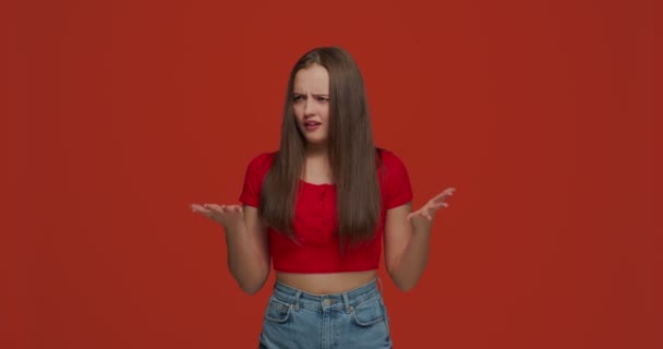 Upset irritated shocked young teen girl spreading hands with shock and misunderstanding, asking what, feeling outraged — Stock Video