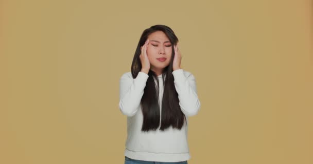 Doente asiático jovem sofrendo dor de cabeça, massageando templos. Sintoma de gripe, stress, fadiga e enxaqueca — Vídeo de Stock