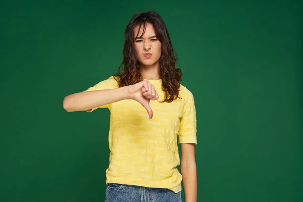 Mladá dívka ukazuje palec dolů gestem, které se jí nelíbí. Negativní zpětná vazba, špatné hodnocení kvality, nesouhlas nedoporučuje — Stock fotografie