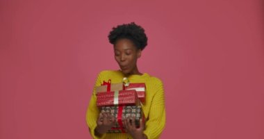 Aşırı neşeli Afrikalı Amerikalı kız elinde bir sürü hediye tutuyordu. Çığlık atıyordu. Doğum günü hediyelerinden şok olmuştu.