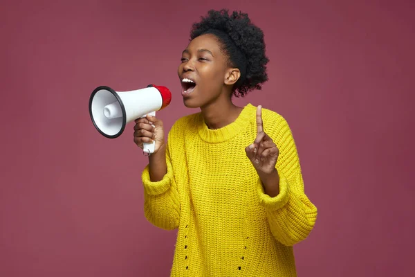 Heyecanlı genç kız megafonla bağırıyor, satışı duyurdu, online mağaza teklifini duyurdu. Kadın hoparlörde bağırıyor.