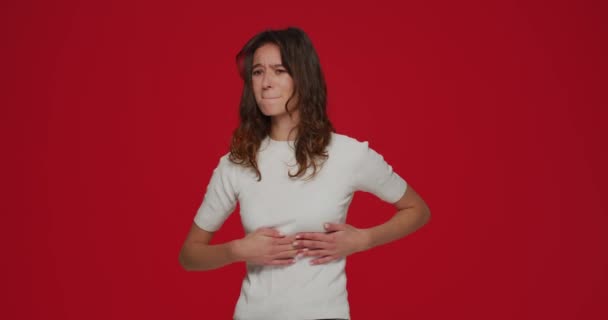 Krankes junges Mädchen mit Muskelschmerzen in der Brust aufgrund eines eingeklemmten Nervs, interkostaler Neuralgie auf rotem Hintergrund — Stockvideo