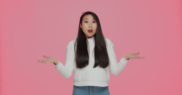 Indignado indignado chocado asiático jovem menina no perplexidade estendendo as mãos, não entendo situação, perguntando o que — Vídeo de Stock