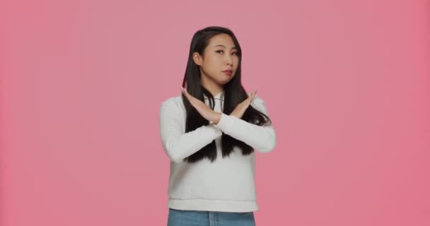 진지 한 젊은 아시아 소녀는 제스처를 멈추고, 안 좋은 제안을 거절하고, 핑크 스튜디오 배경에 대한 제안을 거절 합니다. — 비디오