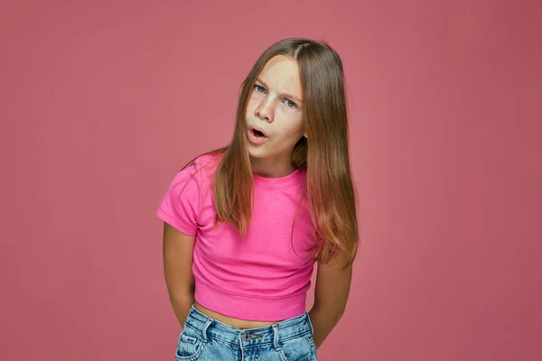 Elégedetlen gyermek lány ráncolja a homlokát, kérdezi, mit akarsz rózsaszín stúdió háttér. Gyerekjogok. Fiatalkorúakra vonatkozó igazságszolgáltatás — Stock Fotó