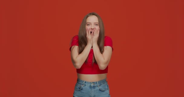 Šťastný odchod mladé dívky vítěz překvapen nečekaným štěstím, šokovaný ohromený slaví vítězství na oranžovém pozadí studia — Stock video