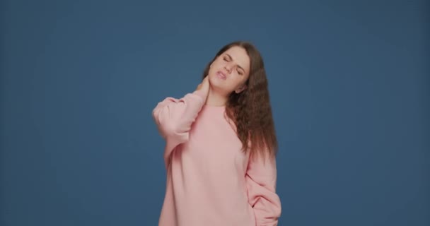 피곤 한 소녀는 목 통증 마사지를 받아 통증을 덜어 주고 긴 컴퓨터 작업, 자궁경부 골다공증으로 인한 통증을 덜어 준다 — 비디오