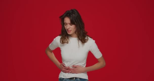 Unhealthy young girl touching belly feel stomach ache. Menstruation period, food allergy or poisoning by junk products — Stock Video