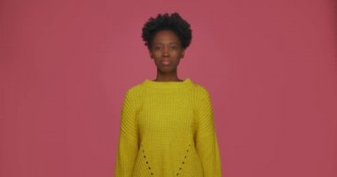 - Bilmiyorum. - Neden? Kafası karışmış genç Afrikalı Amerikalı kız omuzlarını silkiyor, pembe arka planda belirsizlik içinde ellerini açıyor.