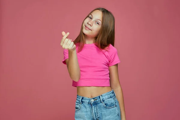 Készpénz gesztus. Aranyos gyermek lány kérni fizetés, pénzügyi jutalom, adósság vagy adomány rózsaszín alapon. Gyerekek zsebpénze. — Stock Fotó
