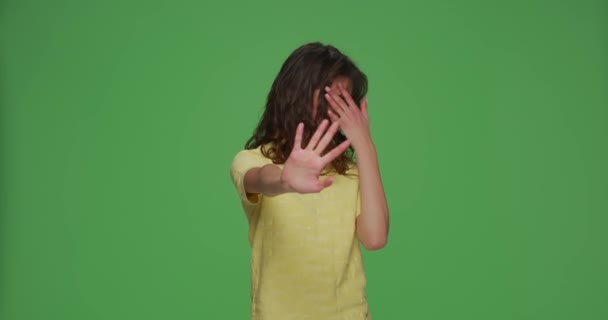 Молода дівчина, що прикриває очі руками, робить стоп жест із виразом страху, відчуває огиду на зеленому фоні хромосоми — стокове відео
