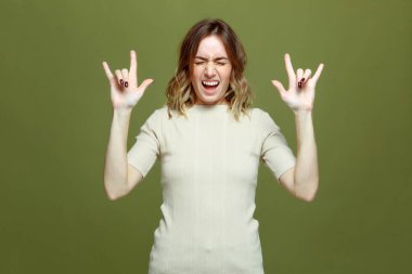 Çıkan mutlu genç kadın elleri ile rock jesti göster çığlıklar, kapalı gözler, başarının tadını çıkar, güzel rock-n-roll müzik