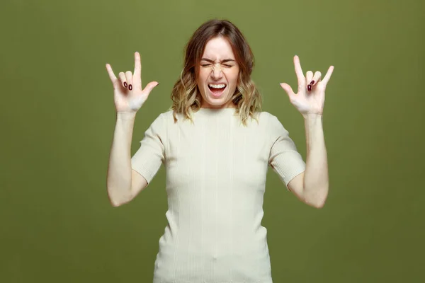 Salir feliz joven muestra gesto de rock por las manos gritando, ojos cerrados, disfrutando del éxito, música rock-n-roll fresco — Foto de Stock