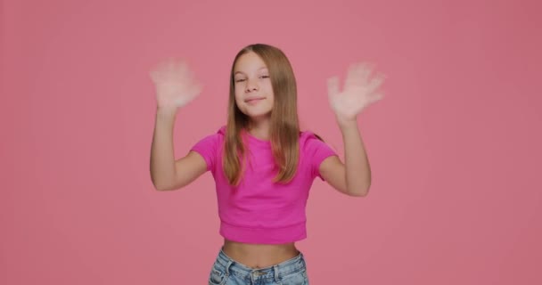 Schattig vriendelijk kind meisje blogger zwaaien handen begroeten, gastvrije abonnees, kennismaken met op roze achtergrond — Stockvideo