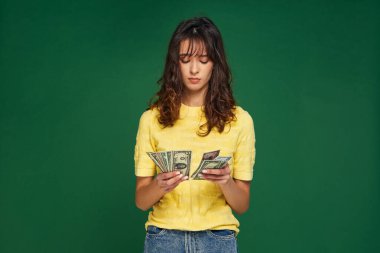 Endişeli genç kız para sayıyor. Hüsrana uğramış kadın kontu nakit para ve kazanç getiriyor. Parasızlık, ekonomik kriz.