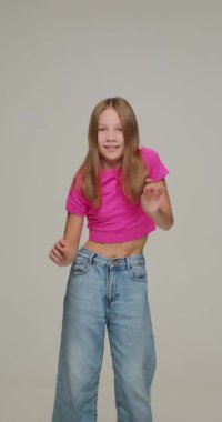 Müzik ritmiyle dans eden mutlu kız çocuğunun dikey videosu. Çağdaş dans okulu reklamcılığı