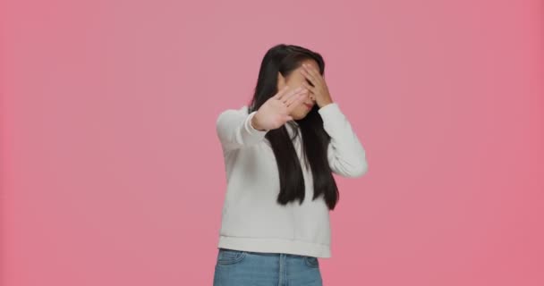 Jag vill inte se. Rädd ung asiatisk flicka täcker ögon som visar stopp gest, skaka huvudet nej på rosa studio bakgrund — Stockvideo