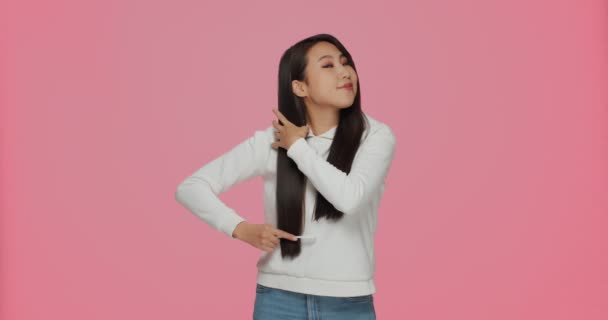 Vrij jong Aziatisch jong meisje brunette kammen lang gezond haar. Haarverzorging hairstyling cosmetica reclame — Stockvideo