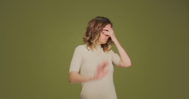 Nechci to vidět. Strach z toho, že mladá žena zakrývající oči gestem ruky, vystrašená na zeleném pozadí — Stock video